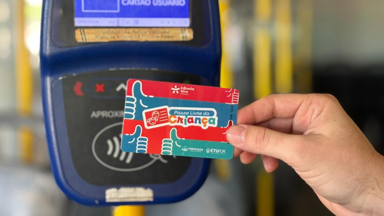 novo modelo do cartão, com predominância das cores verde e vermelho, sendo passado numa catraca de ônibus